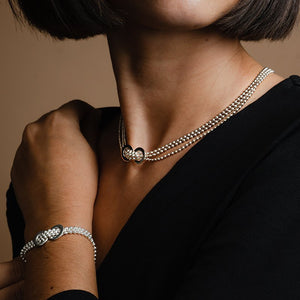 Collier en argent très élégant et intemporel. Composé de trois rangs de perles d'argent passant tous au centre du cou dans deux anneaux soudés l'un à l'autre.
