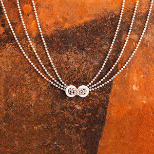 Collier en argent très élégant et intemporel. Composé de trois rangs de perles d'argent passant tous au centre du cou dans deux anneaux soudés l'un à l'autre.